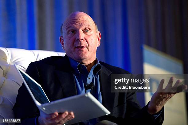 Steve Ballmer, chief executive officer of Microsoft Corp., speaks as he holds a Samsung laptop computer running Windows 8 software during an event at...