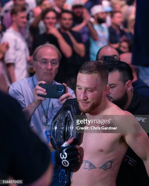 Justin Gaethje carries his belt as he leaves the ring after beating Dustin Poirier during their BMF Title Lightweight fight at UFC 291 at the Delta...
