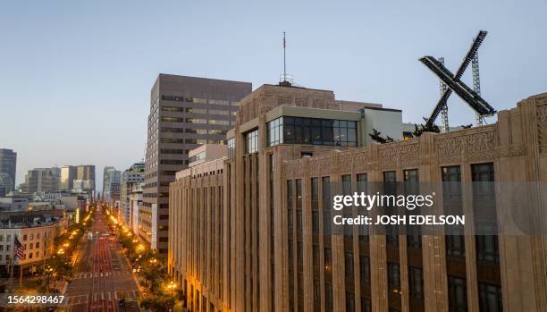 An aerial view shows a newly constructed X sign on the roof of the headquarters of the social media platform previously known as Twitter, in San...