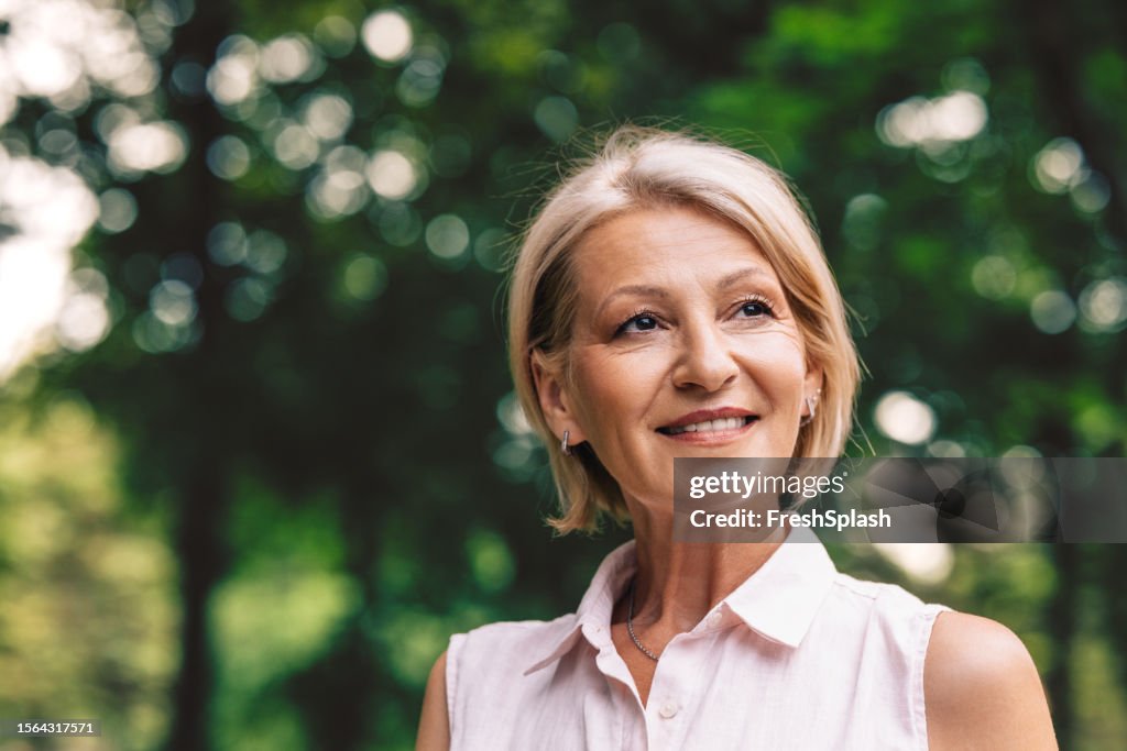 A Happy Beautiful Blonde Woman Looking Away While Relaxing In Nature