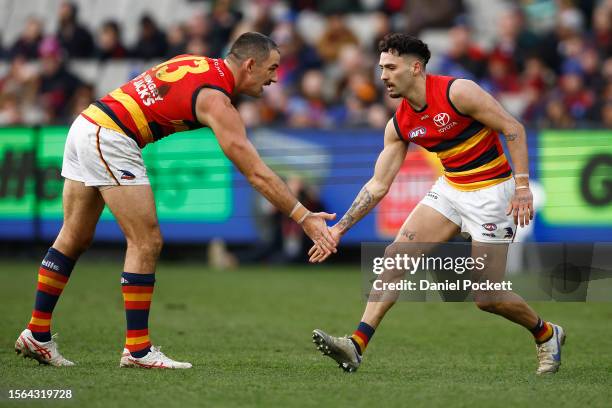 Izak Rankine of the Crows celebrates with Taylor Walker of the Crows after kicking a goal during the round 19 AFL match between Melbourne Demons and...