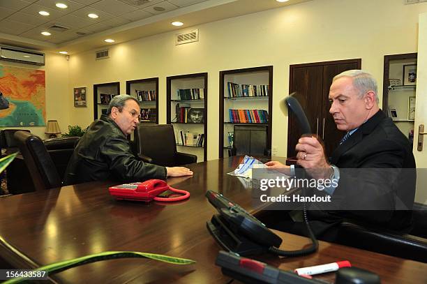 In this handout photo provided by the Israeli Ministry of Defence, Israeli Prime Minister Benjamin Netanyahu and Defense Minister Ehud Barak hold...