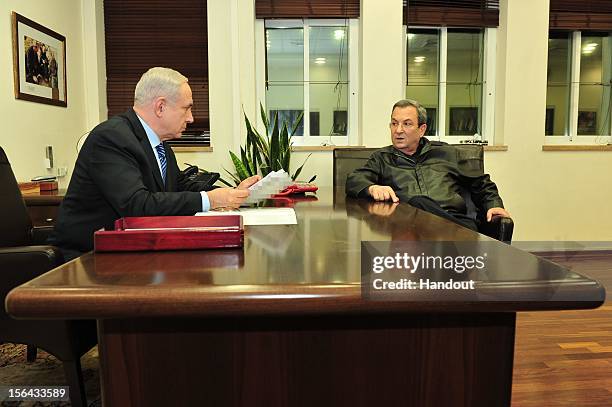 In this handout photo provided by the Israeli Ministry of Defence, Israeli Prime Minister Benjamin Netanyahu and Defense Minister Ehud Barak hold...