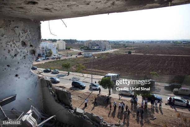 People gather below an apartment which was hit by a rocket fired by Palestinian militants, killing three people on November 15, 2012 in Kiryat...