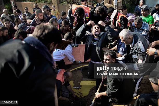 Palestinian man calls for help as he and others try to save a man trapped under his car just after an Israeli air raid on the area of Twaam in the...