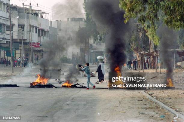 Palestinian youth fuels with tyres a burning barricade in Gaza during violent demonstrations on December 10, 1987 on the second day of the Intifada....