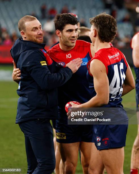 Demons head coach Simon Goodwin celebrates with Christian Petracca of the Demons and Taj Woewodin of the Demons after winning the round 19 AFL match...