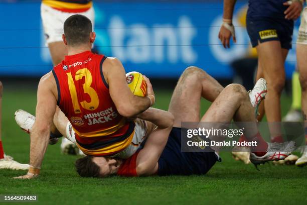 Taylor Walker of the Crows sits on the head of Jake Lever of the Demons after marking the ball during the round 19 AFL match between Melbourne Demons...