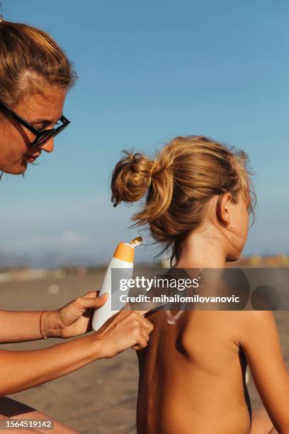 mother applying sunscreen - car sun screen stock pictures, royalty-free photos & images