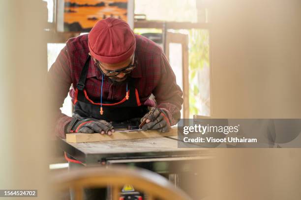 professional carpenter working with a measuring tape and pencil in wood plank. - wood workshop stock pictures, royalty-free photos & images