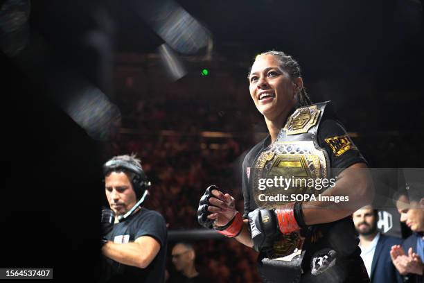 Samantha Jean-François smiling with the Women's Strawweight Title resting on her shoulder after her win in the co-main event of Hexagone MMA 10. In...