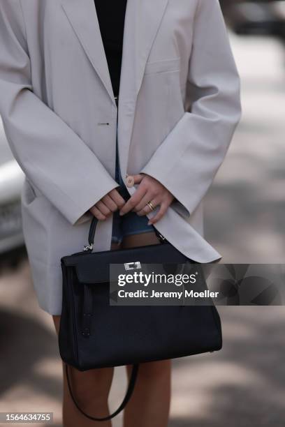 Isabelle Hartmann is seen wearing black narrow sunglasses from Saint Laurent, an oversize beige blazer from The Frankie Shop, underneath a black top...