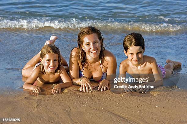 mother with two children on beach - la manga foto e immagini stock