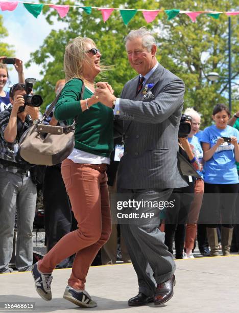 Britain's Prince Charles dances with Lisa Shannon in a 'dance-o-mat' gap filler as he and his wife Camilla visit Oxford Terrace in Christchurch on...