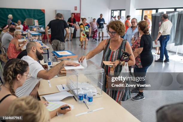 Aurora Gálvez holds her dog as she casts her ballot in the general elections at Leonor Canalejas public school on July 23, 2023 in Benidorm, Spain....