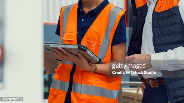 closeup of professional male industrial engineers talk with factory worker while using tablet in manufacturing factory. working in manufacturing plant or production plant. - switchboard operator stock pictures, royalty-free photos & images