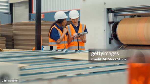 professional female industrial engineers discuss new project in manufacturing factory. working in manufacturing plant or production plant. - papelão corrugado imagens e fotografias de stock