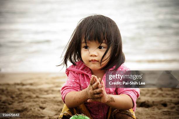 a girl playing at the white-sand beach - girl blowing sand stock-fotos und bilder