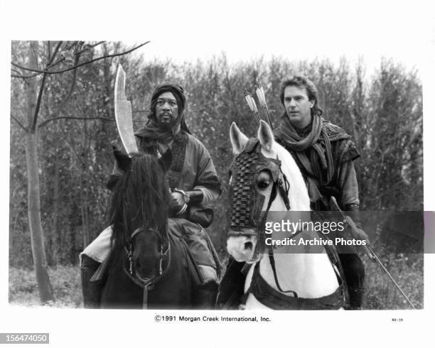 Morgan Freeman and Kevin Costner arm themselves on horseback in a scene from the film 'Robin Hood: Prince Of Thieves', 1991.