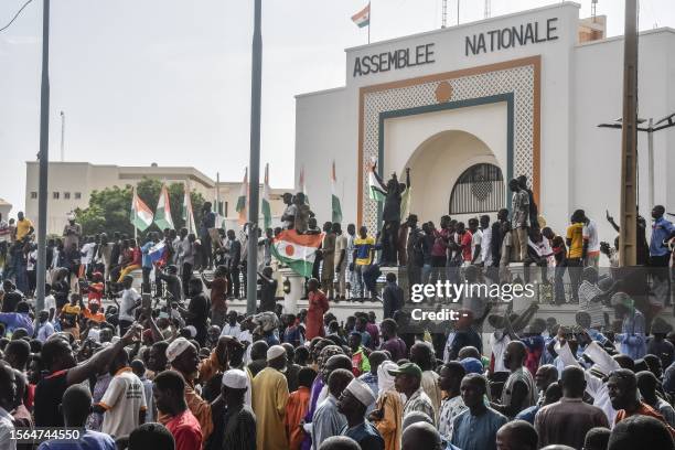 Supporters wave Nigerien's flags as they rally in support of Niger's junta in front of the National Assembly in Niamey on July 30, 2023. Niger's...