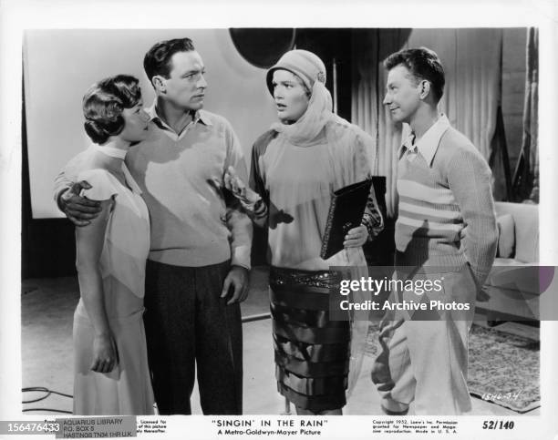 Debbie Reynolds and Gene Kelly listen to Jean Hagen and Donald O'Connor in a scene from the film 'Singin' In The Rain', 1952.