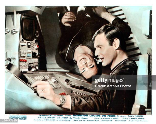 Paul Mantee hangs weightless while Adam West takes command in a scene from the film 'Robinson Crusoe On Mars', 1964.