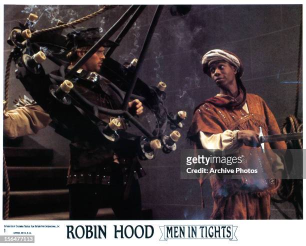Cary Elwes is caught in a chandelier next to Dave Chappelle in a scene from the film 'Robin Hood: Men In Tights', 1993.