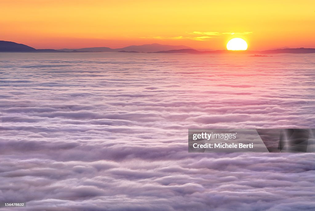 Sunset over fog created by a temperature inversion