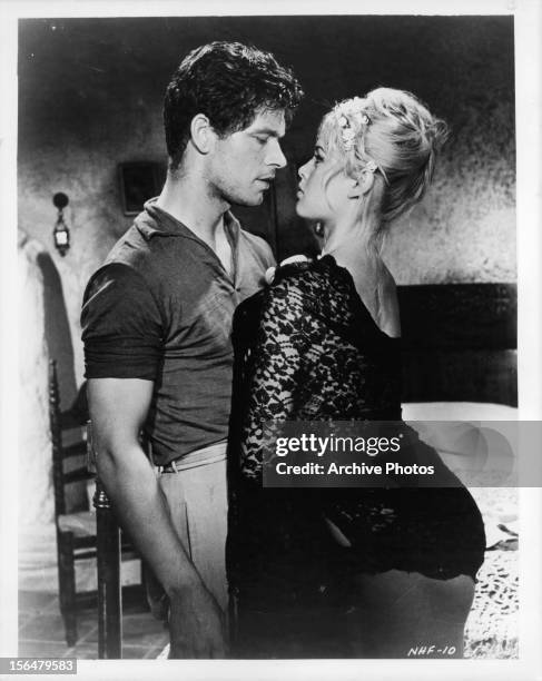 Brigitte Bardot in a seductive stand as she leans into Stephen Boyd in a scene from the film 'The Night Heaven Fell', 1958.