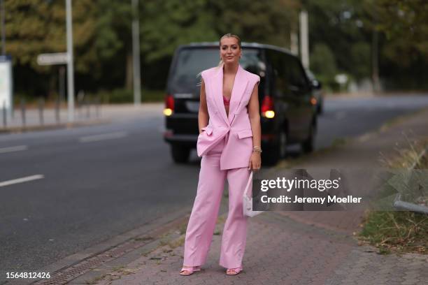 Karolina Kauer is seen wearing a pink two-piece suit from Riani outside during the Riani Show on July 22, 2023 in Dusseldorf, Germany.