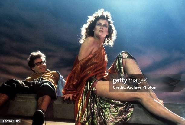 Smiling Rick Moranis looking up at Sigourney Weaver in a scene from the film 'Ghostbusters', 1984.