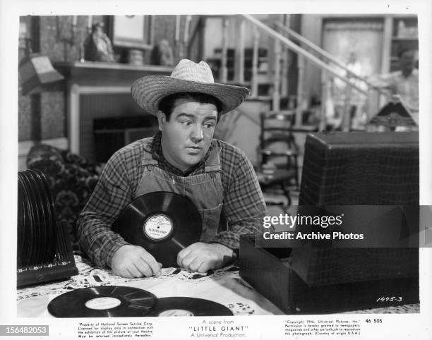 Lou Costello plays records in a scene from the film 'Little Giant', 1946.