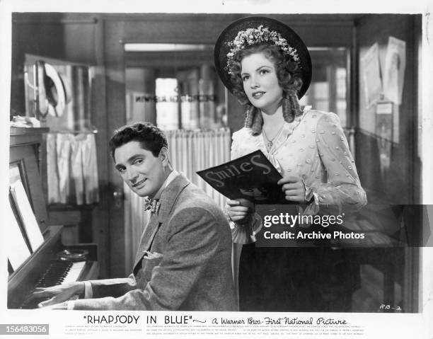 Robert Alda sings with Joan Leslie in a scene from the film 'Rhapsody In Blue', 1945.