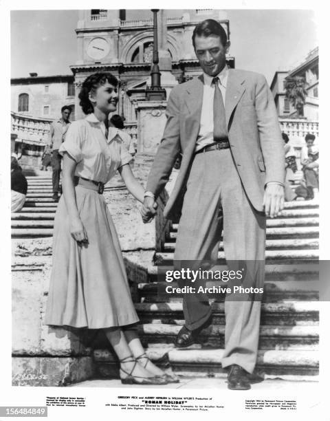 Audrey Hepburn holds hands with Gregory Peck in a scene from the film 'Roman Holiday', 1953.