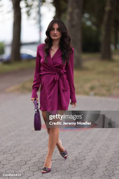 Merna Hermez is seen wearing a complete Riani outfit, consisting of a long-sleeved wrapped mini dress in purple, a purple/glitter bag and pumps...