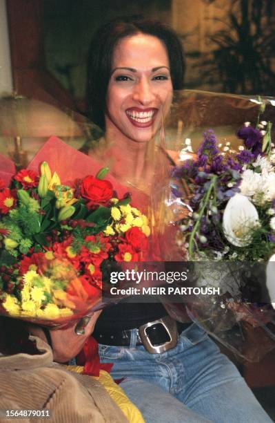 Dana International, the transsexual Israeli singer who won the Eurovision song contest in England, smiles happily upon her arrival at Ben Gurion...