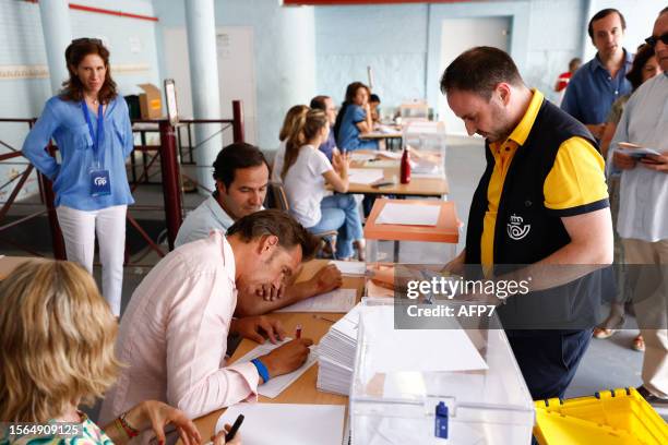 Postman arrives in a polling station carrying postal vote during Spain's general election at Ramiro de Maeztu School on July 23, 2023 in Madrid,...