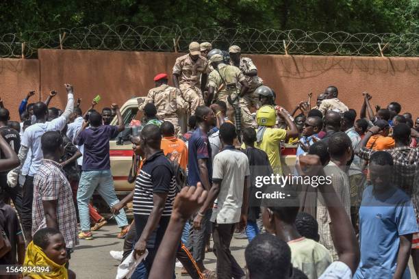 Protesters cheer Nigerien troops as they gather in front of the French Embassy in Niamey during a demonstration that followed a rally in support of...