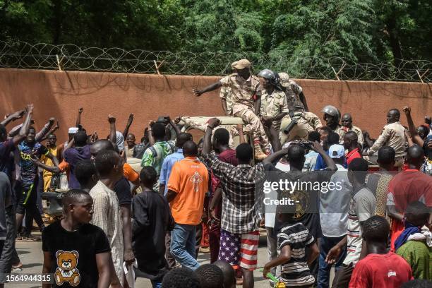Protesters cheer Nigerien troops as they gather in front of the French Embassy in Niamey during a demonstration that followed a rally in support of...