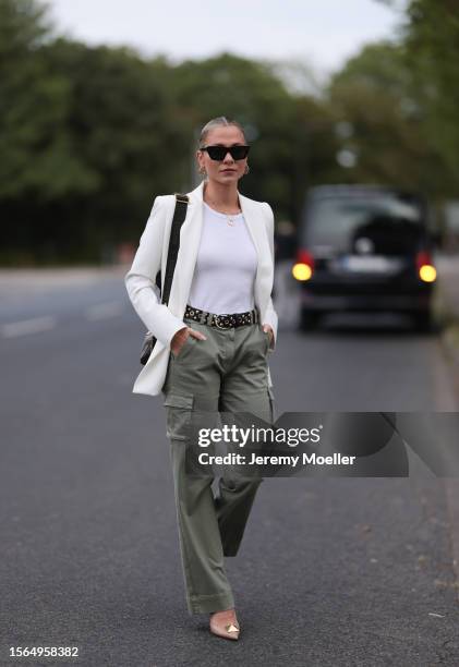 Valentina Pahde is seen wearing a white blazer, underneath a white top, green cargo pants, a black belt with lugs and beige pointed pumps outside...