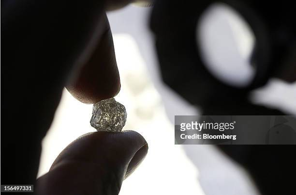 An employee inspects an uncut diamond at DTC Botswana, a unit of De Beers, in Gaborone, Botswana, on Thursday, Oct. 25, 2012. De Beers, the biggest...