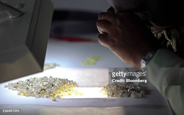 An employee uses a light table to sort through a collection of uncut diamonds at DTC Botswana, a unit of De Beers, in Gaborone, Botswana, on...