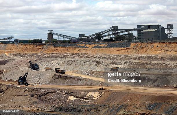 Excavators and mining trucks operate in a pit beneath the main kimberlite rock processing facility at Jwaneng mine, operated by the Debswana Diamond...