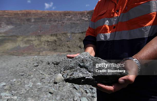 Mineworker displays a lump of diamond-bearing kimberlite rock from the pit floor in this arranged photograph at the Jwaneng mine, operated by the...