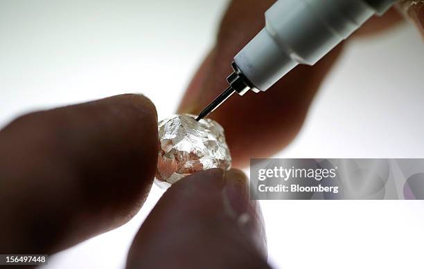 An employee marks up a diamond with cutting lines at the Shrenuj Botswana Ltd. Sightholder office in Gaborone, Botswana, on Thursday, Oct. 25, 2012....