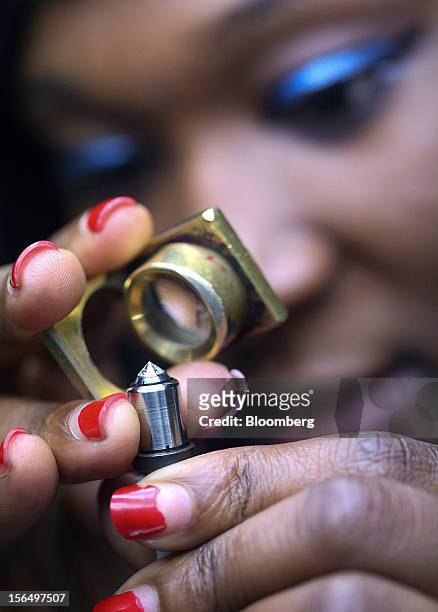 An employee inspects a diamond during the polishing process using an automated polishing machine at the Shrenuj Botswana Ltd. Sightholder office in...