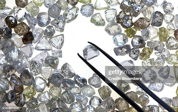 An uncut diamond is selected from a collection of colorless and colored diamonds on a sorting table at DTC Botswana, a unit of De Beers, in Gaborone,...