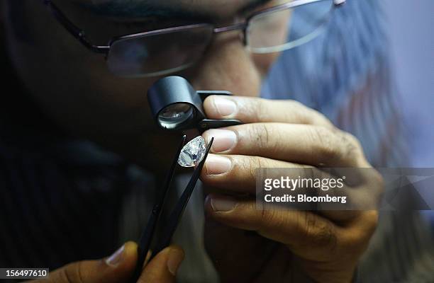 An employee uses a magnifier to inspect a finished pear-shaped diamond before final classification at the Shrenuj Botswana Ltd. Sightholder office in...