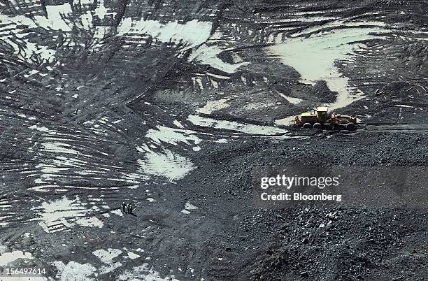 Mineworkers stand near a digger on diamond-bearing kimberlite rock at the base of the Jwaneng mine, operated by the Debswana Diamond Co., a joint...