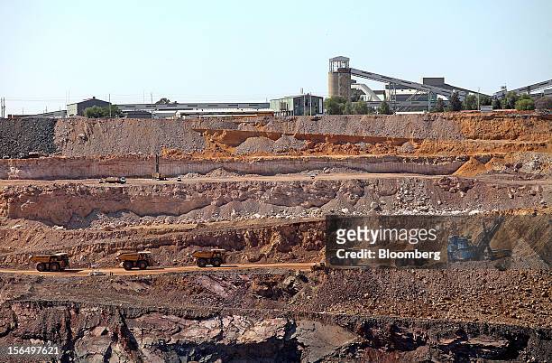 Mining trucks wait to collect excavated rock on a pit road beneath the main kimberlite rock processing facility at the Jwaneng mine, operated by the...